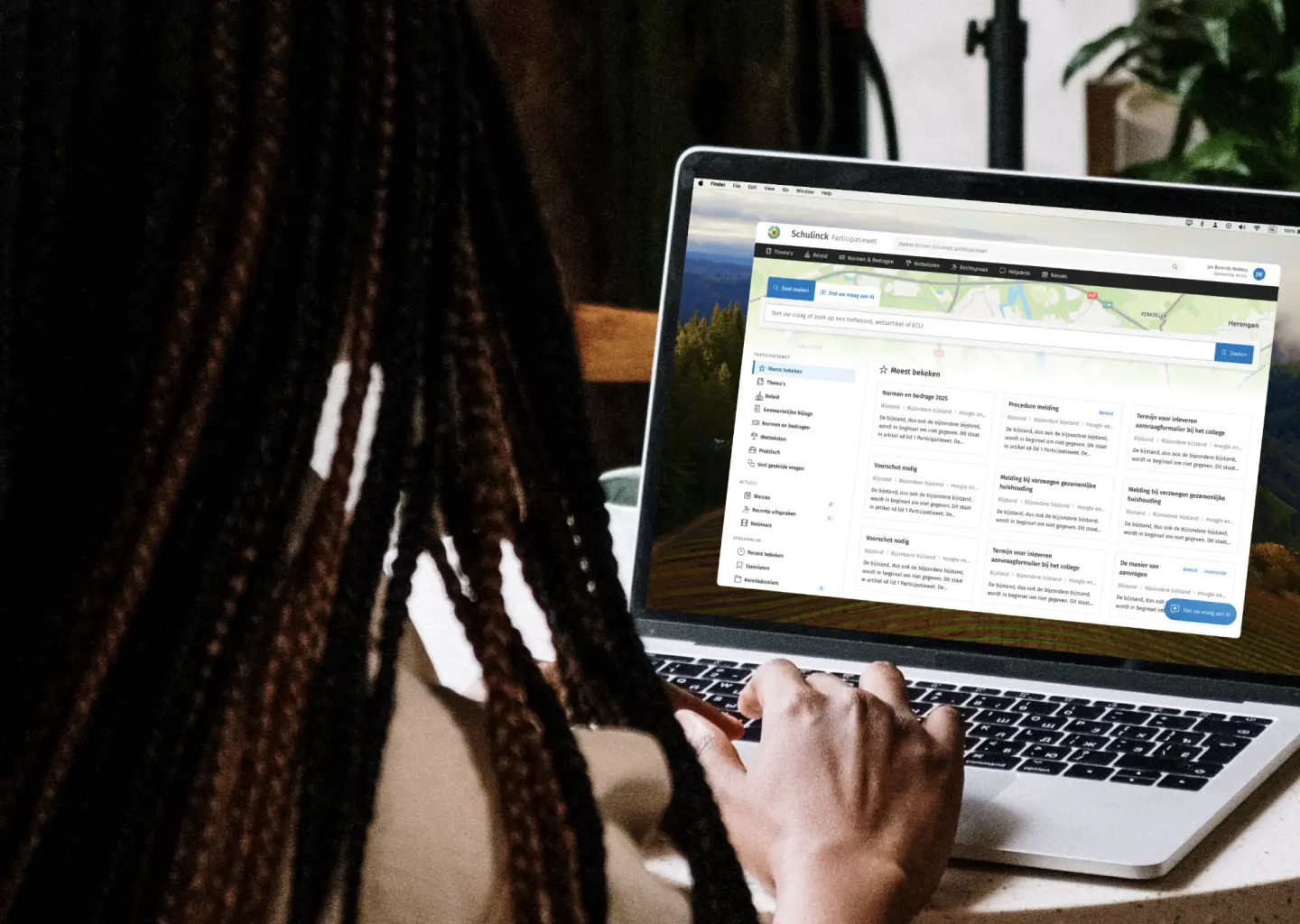 Someone working at a laptop showing the Schulinck knowledge platform.